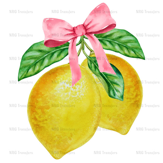 A pair of bright yellow lemons with green leaves and a pink bow tied around them.