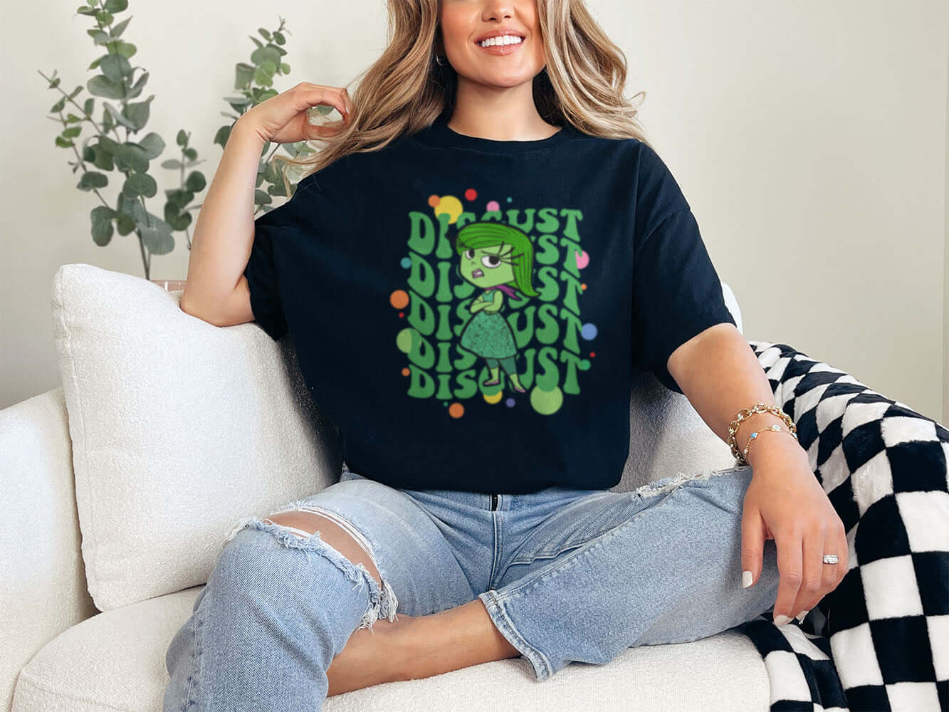 a woman sitting on a couch wearing a t - shirt