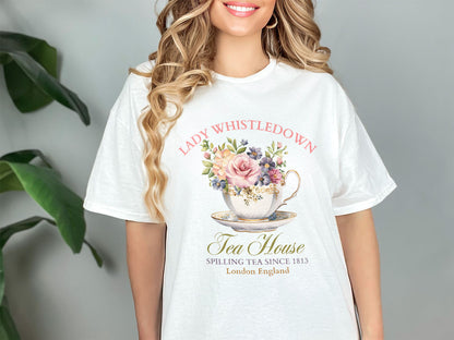 a woman wearing a white t - shirt with a floral teacup on it