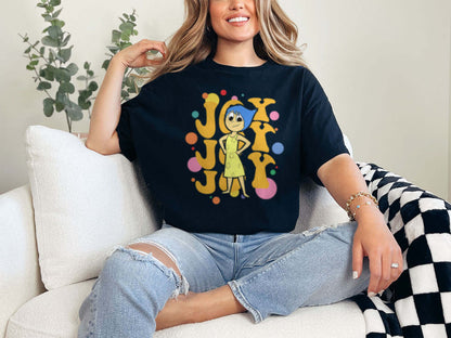 a woman sitting on a couch wearing a joy t - shirt