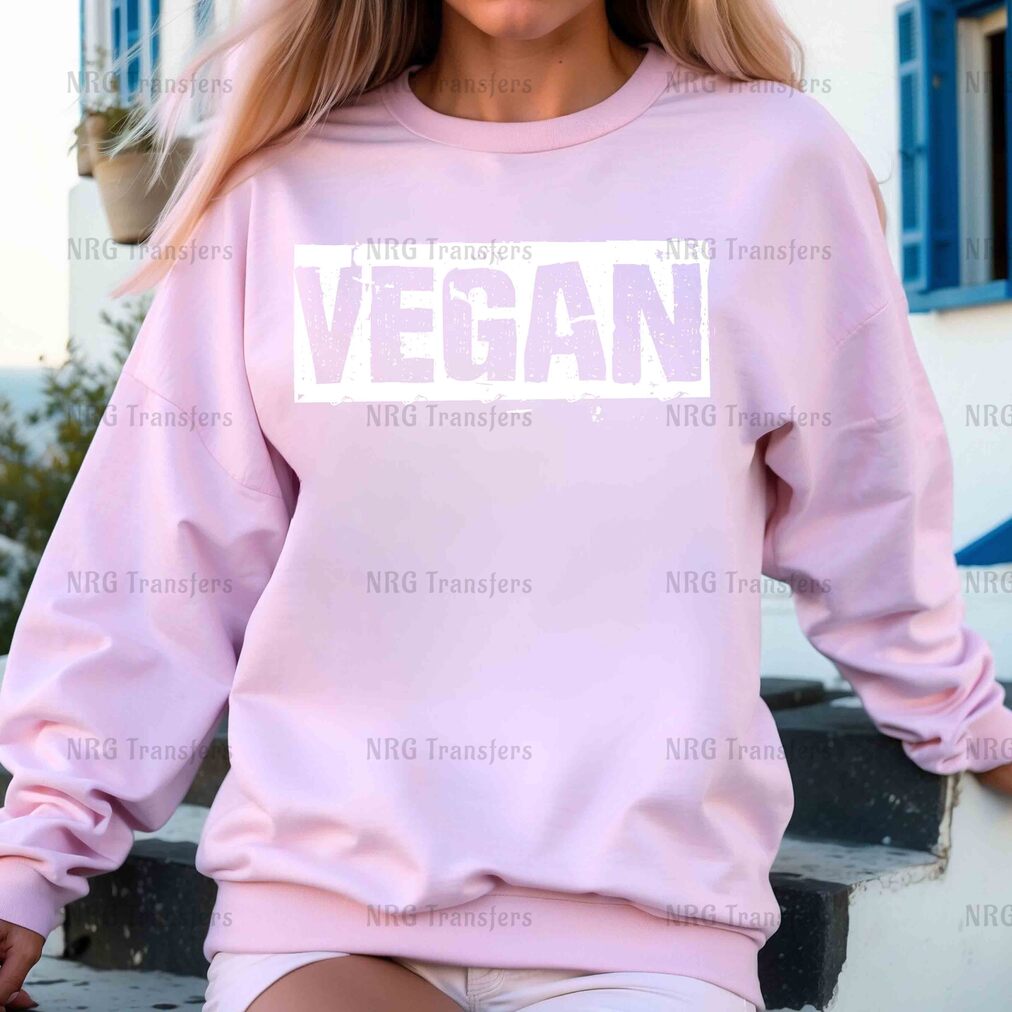 a woman wearing a pink sweatshirt with the word vegan on it