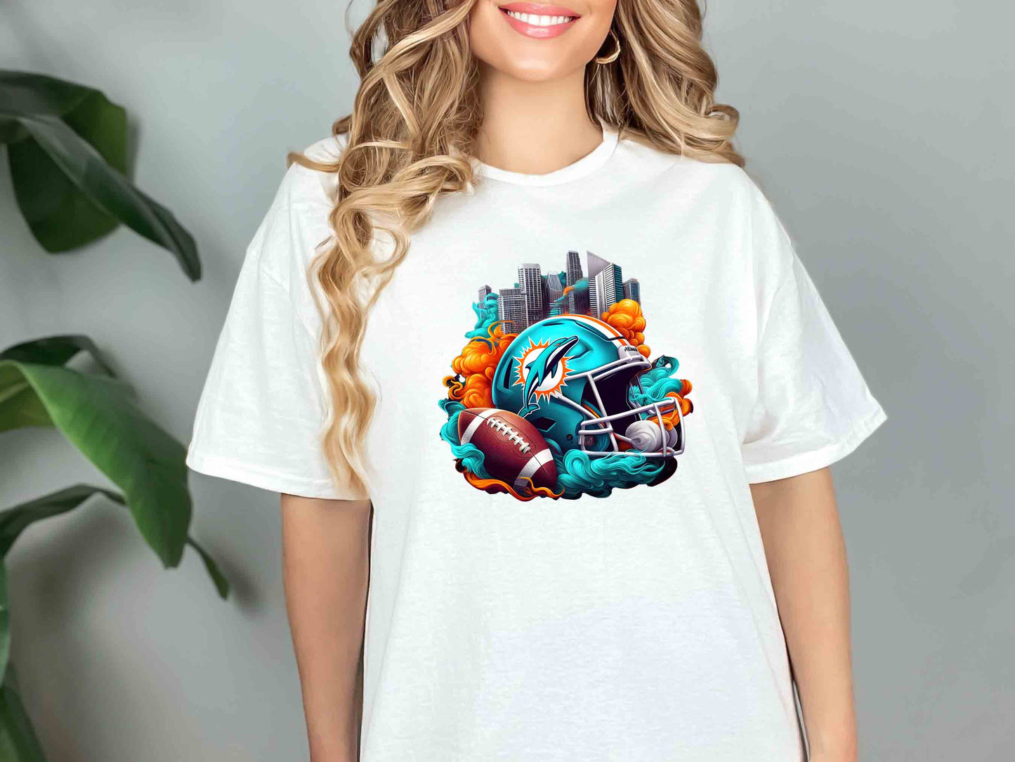 a woman wearing a white t - shirt with a graphic of a football helmet and