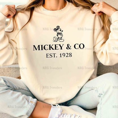 a woman sitting on the floor wearing a mickey and co sweatshirt