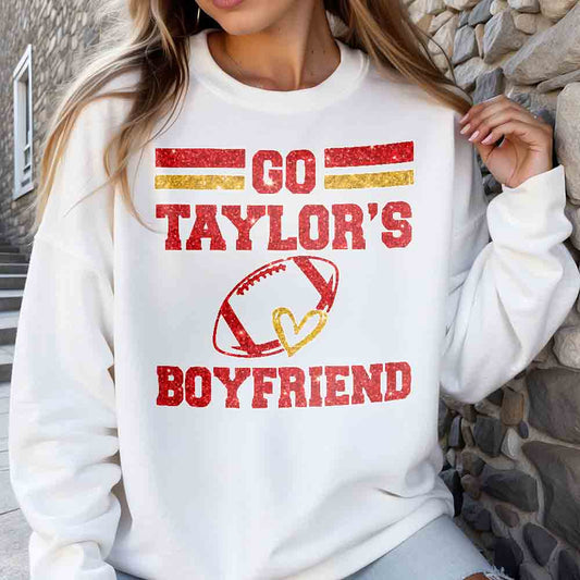 a woman wearing a sweatshirt that says go taylor's boyfriend