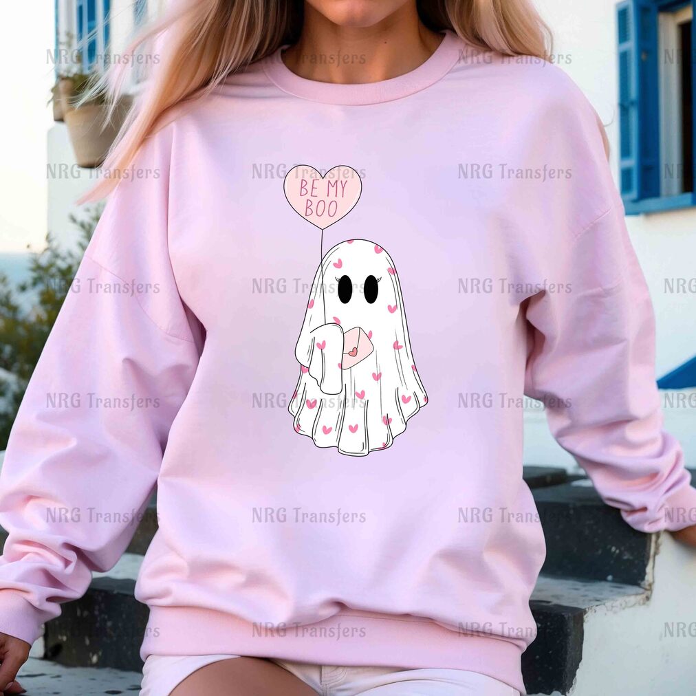 a woman wearing a pink sweatshirt with a ghost on it