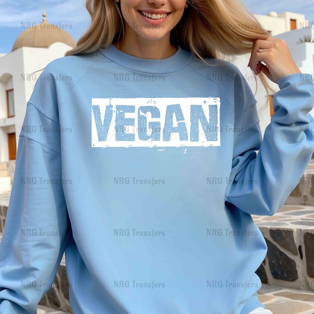 a woman wearing a blue sweatshirt with the word vegan on it