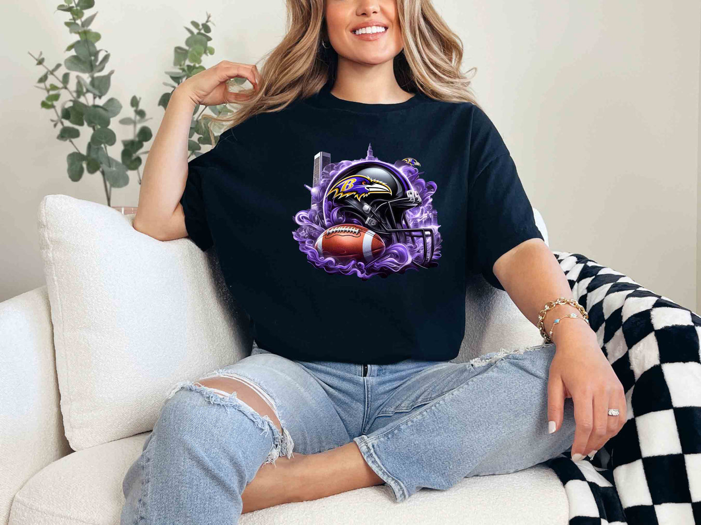 a woman sitting on a couch wearing a baltimore football t - shirt