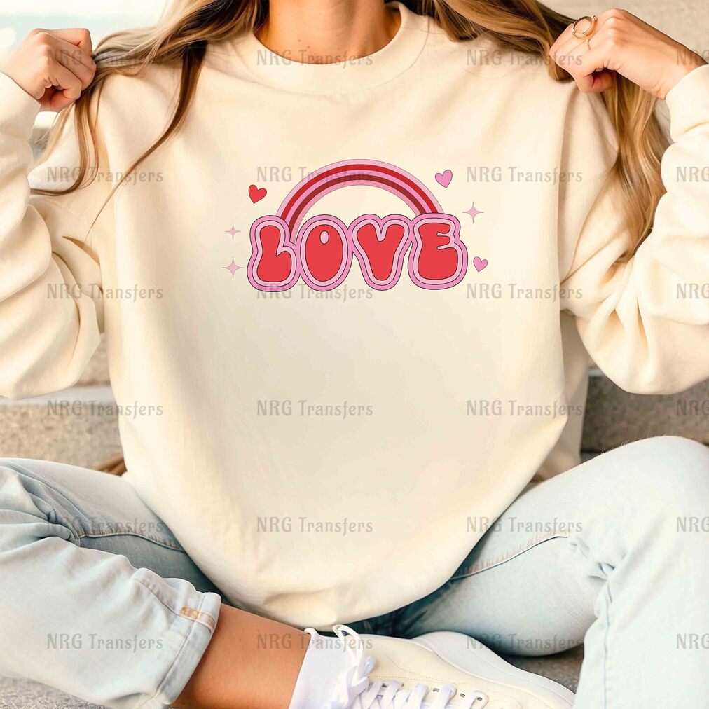 a woman sitting on a couch wearing a sweatshirt with the word love on it