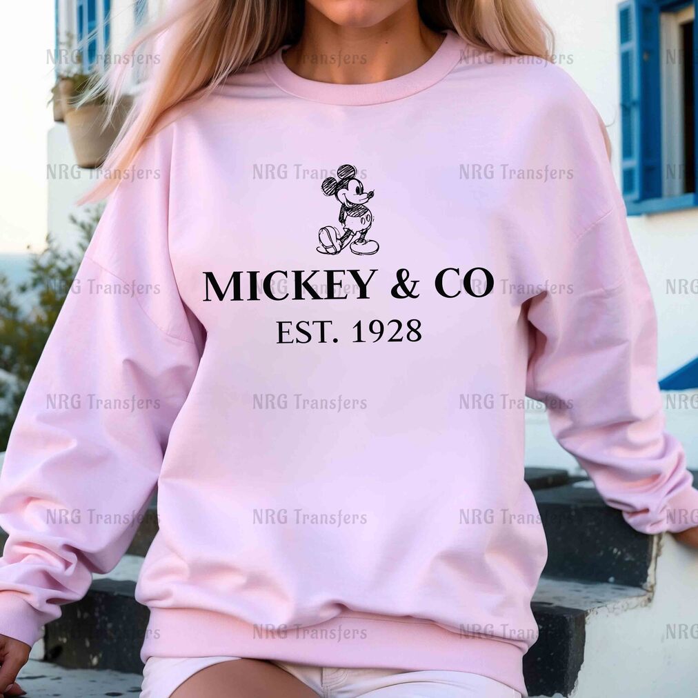 a woman wearing a pink mickey and co sweatshirt