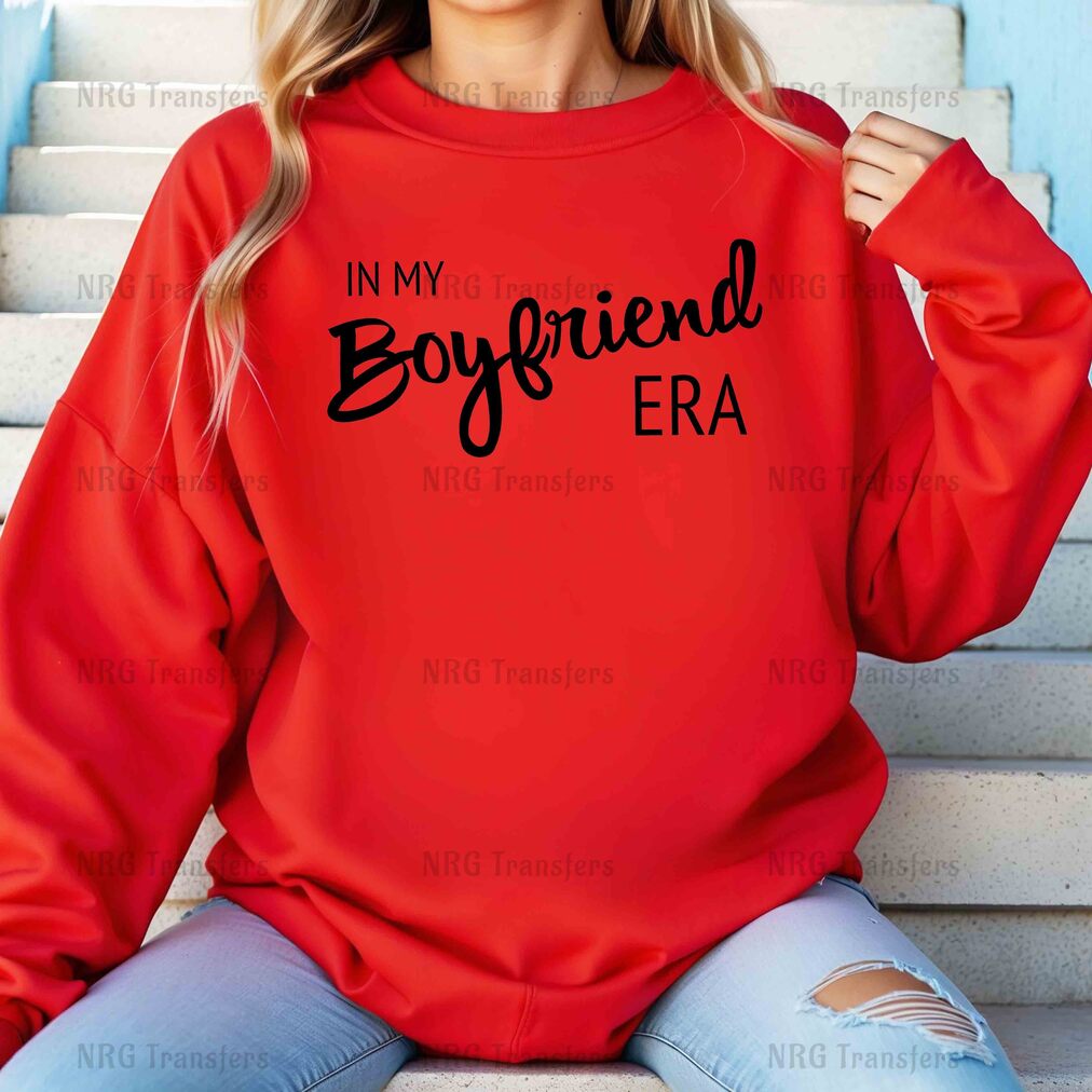 a woman wearing a red sweatshirt that says in my boyfriend era